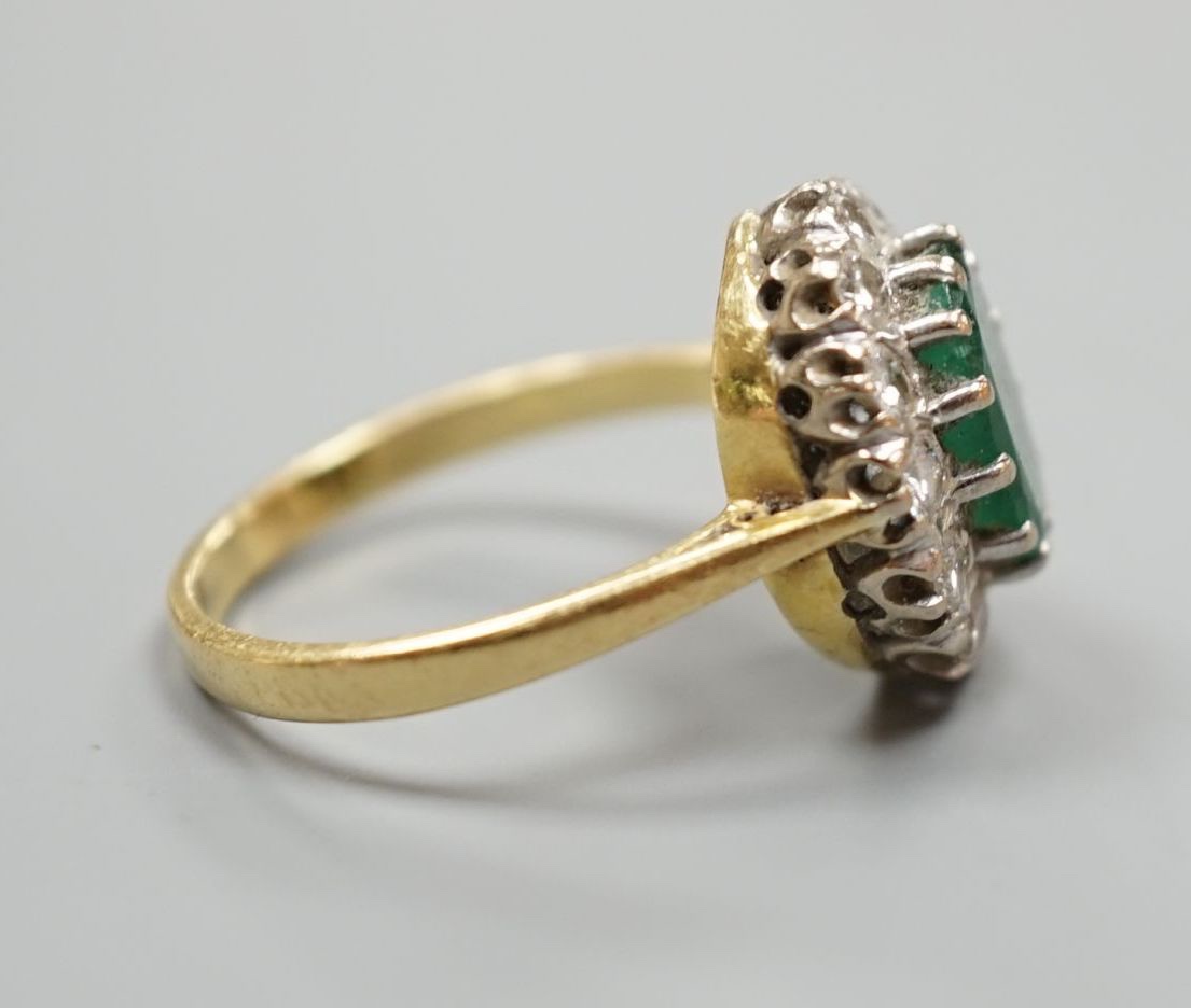 A yellow metal, emerald and diamond set oval cluster ring, size P/Q, gross weight 5 grams.